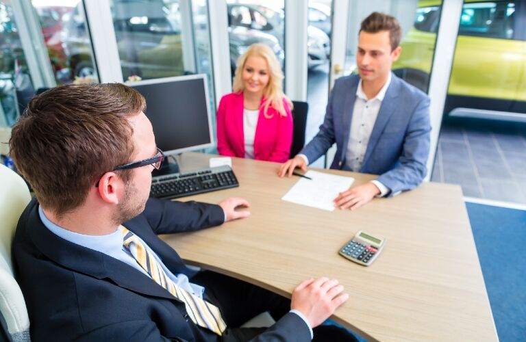 couple at the dealership doing paperwork